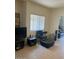 Well-lit living room with tile flooring, TV, comfortable chair, and a view to the outdoor living area at 7609 E Indian Bend Rd # 1012, Scottsdale, AZ 85250