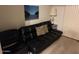 Cozy living room featuring a dark futon, chair, and decorative art print at 7609 E Indian Bend Rd # 1012, Scottsdale, AZ 85250