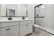 Modern bathroom with double sinks, a white vanity, and a glass-enclosed shower at 7657 W Minton St, Laveen, AZ 85339