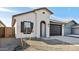 View of front of home with desert landscaping, black shutter, and dark two car garage at 7657 W Minton St, Laveen, AZ 85339