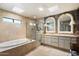 Bright bathroom featuring a soaking tub, glass-enclosed shower, and dual vanities at 7746 E Bisbee Rd, Scottsdale, AZ 85258