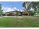 Charming home with a well-manicured lawn, desert landscaping, and a stylish wood garage door at 7746 E Bisbee Rd, Scottsdale, AZ 85258