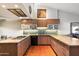 Spacious kitchen features granite countertops, modern cabinetry, stainless steel appliances and brick flooring at 7746 E Bisbee Rd, Scottsdale, AZ 85258