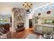 Cozy living room with stone fireplace, tiled floors, and an open layout at 7746 E Bisbee Rd, Scottsdale, AZ 85258