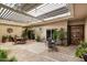 Charming covered patio with ample seating, lush plants, and stylish pavers, perfect for relaxation at 7746 E Bisbee Rd, Scottsdale, AZ 85258