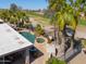 Aerial view of a backyard featuring a pool, hot tub, and a lush green golf course at 80 S Laura Ln, Casa Grande, AZ 85194