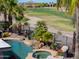 A beautiful backyard with a pool, spa, lush greenery, and a view of the golf course at 80 S Laura Ln, Casa Grande, AZ 85194