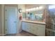 Bright bathroom with double sinks, tile countertops, and a tiled shower entrance at 80 S Laura Ln, Casa Grande, AZ 85194