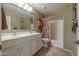Bathroom featuring a double sink vanity, tiled floor, and a shower-tub combo at 80 S Laura Ln, Casa Grande, AZ 85194