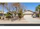 Charming home exterior with mature trees, a two-car garage, and desert landscaping at 80 S Laura Ln, Casa Grande, AZ 85194