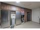 Garage area equipped with stainless steel refrigerators, storage cabinets, and laundry facilities at 80 S Laura Ln, Casa Grande, AZ 85194