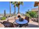 Outdoor patio featuring a fireplace, seating area and palm trees overlooking the golf course at 80 S Laura Ln, Casa Grande, AZ 85194