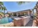 Backyard pool with an outdoor kitchen and patio with ample seating at 80 S Laura Ln, Casa Grande, AZ 85194