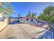 Cozy single-story home featuring a large driveway and xeriscaped yard with a mature tree at 10917 W Apache St, Avondale, AZ 85323