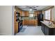 Kitchen with wooden cabinets, black appliances, and granite countertops at 10917 W Apache St, Avondale, AZ 85323