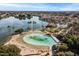 Scenic aerial view showcasing the lagoon with sandy beach and community amenities amidst lush landscaping at 1101 N Peppertree Dr, Gilbert, AZ 85234
