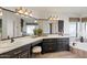 Bright bathroom featuring dual sinks, a makeup vanity area, and a separate soaking tub at 1101 N Peppertree Dr, Gilbert, AZ 85234