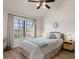 Bright bedroom with a ceiling fan, light-colored walls, and a large window for natural light at 1101 N Peppertree Dr, Gilbert, AZ 85234