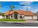 Charming single-story home with a lush green lawn, mature landscaping, and a beautiful red tile roof at 1101 N Peppertree Dr, Gilbert, AZ 85234