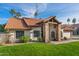 Charming house features a red tile roof, stone accents, a manicured lawn, and lush landscaping at 1101 N Peppertree Dr, Gilbert, AZ 85234