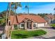 Well-maintained single-story home with a red tile roof, stone accents, an attached garage, and lush landscaping at 1101 N Peppertree Dr, Gilbert, AZ 85234