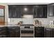 Close-up of the kitchen stove, backsplash, granite countertops, and dark cabinetry at 1101 N Peppertree Dr, Gilbert, AZ 85234