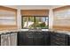 Kitchen with a stainless steel dishwasher, dark cabinets, granite countertops, and a window at 1101 N Peppertree Dr, Gilbert, AZ 85234