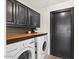 A functional laundry room with a washer, dryer, and overhead storage cabinets at 1101 N Peppertree Dr, Gilbert, AZ 85234