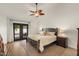 Bedroom with a ceiling fan, wood floors, and a bed with nightstands at 1101 N Peppertree Dr, Gilbert, AZ 85234