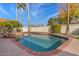Refreshing pool featuring a tranquil rock waterfall, swaying palm trees, and desert landscaping at 1101 N Peppertree Dr, Gilbert, AZ 85234