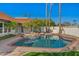 Inviting pool area featuring a tranquil rock waterfall, mature landscaping, and tile roofing at 1101 N Peppertree Dr, Gilbert, AZ 85234
