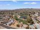 Expansive aerial view showcasing the golf course, lake, desert landscaping, mature trees, and mountain views at 11444 S 51St St, Phoenix, AZ 85044