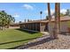Wide shot of a backyard with patio, artificial turf, stone landscaping, and a cozy patio swing at 11444 S 51St St, Phoenix, AZ 85044