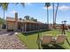Wide shot of a backyard with patio, artificial turf, stone landscaping, and a cozy patio swing at 11444 S 51St St, Phoenix, AZ 85044