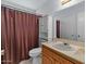 Bathroom with tub-shower, cabinet, and a framed mirror above the vanity at 11444 S 51St St, Phoenix, AZ 85044