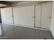 Spacious garage with built-in white storage cabinets and sleek epoxy flooring for organized parking and storage at 11444 S 51St St, Phoenix, AZ 85044
