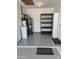 Functional garage interior featuring a water heater, shelving unit, utility sink, and door to the side yard at 11444 S 51St St, Phoenix, AZ 85044