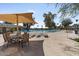 Resort-style pool area features comfortable lounge chairs, and a large parasol at 11444 S 51St St, Phoenix, AZ 85044
