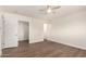 Bedroom with wood floors, ceiling fan, open closet, and a doorway to another room at 15202 N 71St Dr, Peoria, AZ 85381
