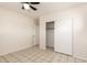 Bright bedroom featuring neutral walls, tile flooring, and a closet with sliding doors at 15202 N 71St Dr, Peoria, AZ 85381