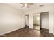 The bedroom features wood floors, a ceiling fan, closet with mirrored doors and an open doorway at 15202 N 71St Dr, Peoria, AZ 85381