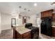 Modern kitchen featuring cherry cabinets, granite island, stainless-steel appliances, and pendant lights at 15202 N 71St Dr, Peoria, AZ 85381