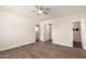 Spacious main bedroom featuring wood floors, a ceiling fan, and doorways to the bath and walk-in closet at 15202 N 71St Dr, Peoria, AZ 85381