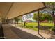 Covered patio overlooking a spacious backyard with mature trees and lush green grass at 15202 N 71St Dr, Peoria, AZ 85381