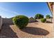 Low maintenance backyard with gravel landscaping, privacy wall, and drought tolerant bushes at 15351 W Port Royale Ln, Surprise, AZ 85379