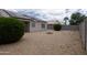 Low-maintenance backyard with gravel landscaping, small plants, and potential for outdoor enjoyment at 15351 W Port Royale Ln, Surprise, AZ 85379