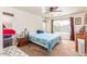Comfortable bedroom featuring neutral carpet, a ceiling fan, and a large window providing ample natural light at 15351 W Port Royale Ln, Surprise, AZ 85379