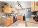 Functional kitchen featuring tile floors, oak cabinets, granite counters, and a bright window over the sink at 15351 W Port Royale Ln, Surprise, AZ 85379