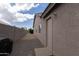 Side yard view with a block wall, gravel, and convenient access door at 15351 W Port Royale Ln, Surprise, AZ 85379
