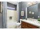A full bathroom showing a combination shower and tub with neutral tile, a dark wall, and a single vanity at 15434 W Big Sky Dr, Surprise, AZ 85374